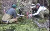 Four people crouching in water holding sampling containers